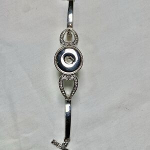 Silver tone bracelet with rhinestone hollow hearts toggle closure